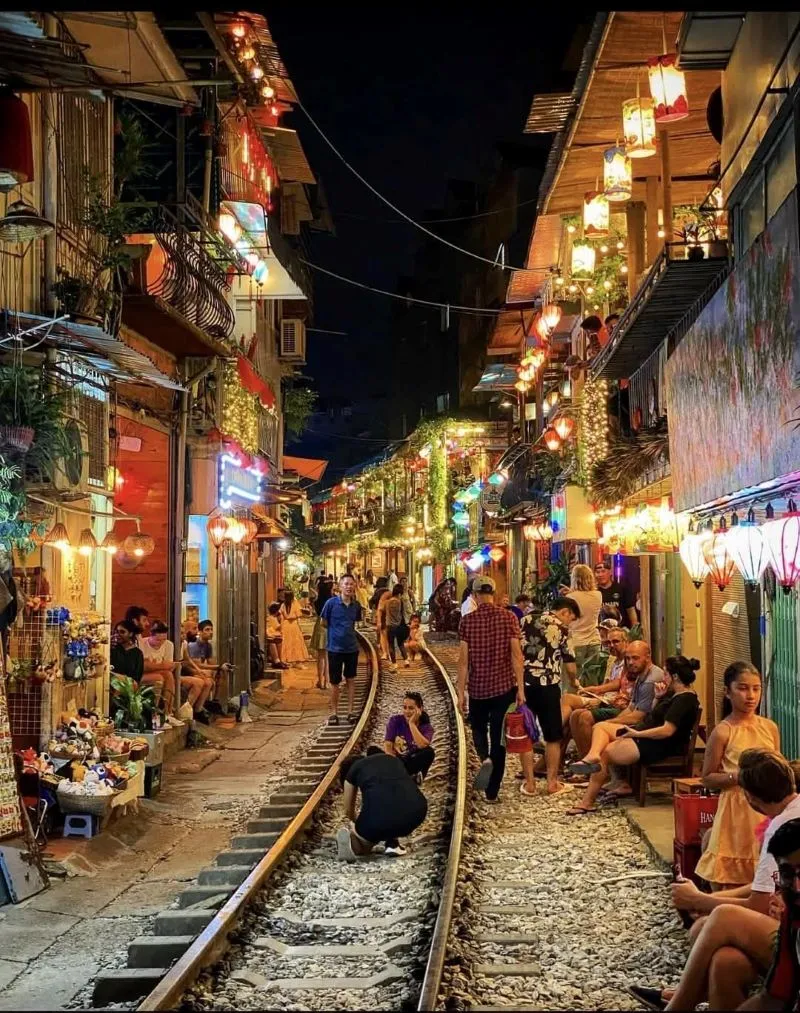 A lively street market with bright lights, crowds, and souvenir stalls filled with unique gifts - Photo Source: Fanpage Travel in your own way
