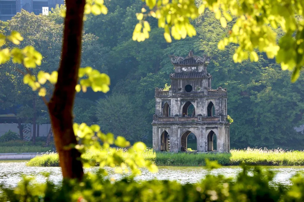Hoan Kiem Lake has shady green trees and a calm water surface, creating a relaxing space - Image source: Joytime