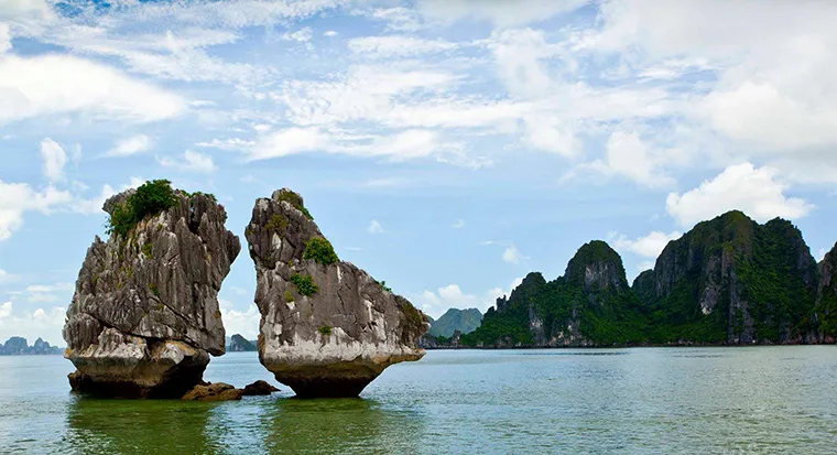 This islet consists of two uniquely shaped limestone formations resembling a rooster and a hen, standing precariously balanced above the emerald waters