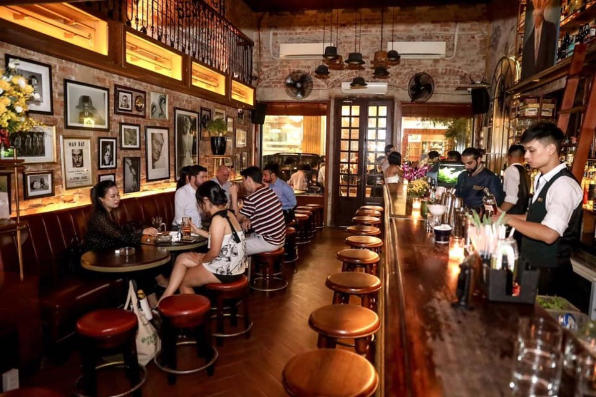 Bartenders mix premium spirits in a vintage inspired speakeasy setting