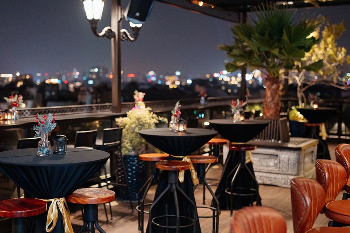 A stylish rooftop terrace offering panoramic night views of the illuminated city skyline