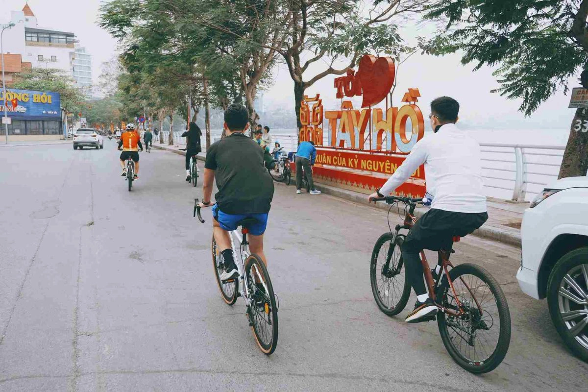 Cyclists enjoying a peaceful morning ride along the shaded paths surrounding the lake
