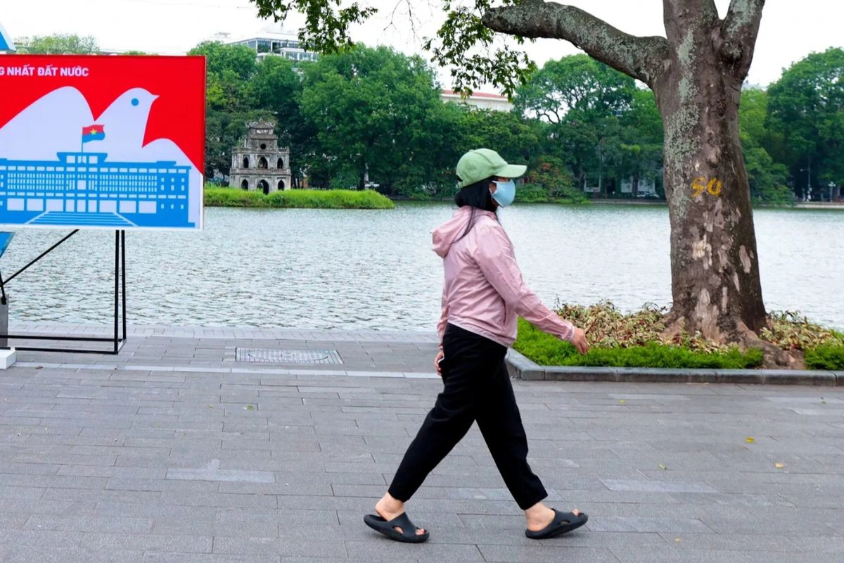 Tourists wearing light jackets while exploring the chilly streets of Hanoi in December
