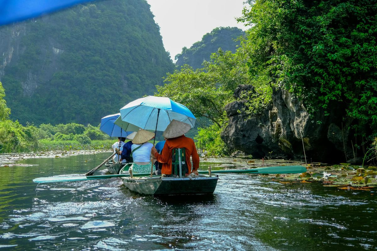 Morning boats glide through Trang An’s limestone valleys and caves