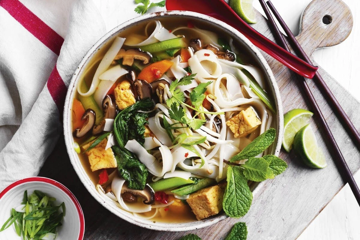 Vegan pho with tofu, mushrooms, and fresh herbs