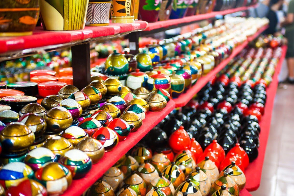 Rows of colorful lacquered souvenirs fill the stalls