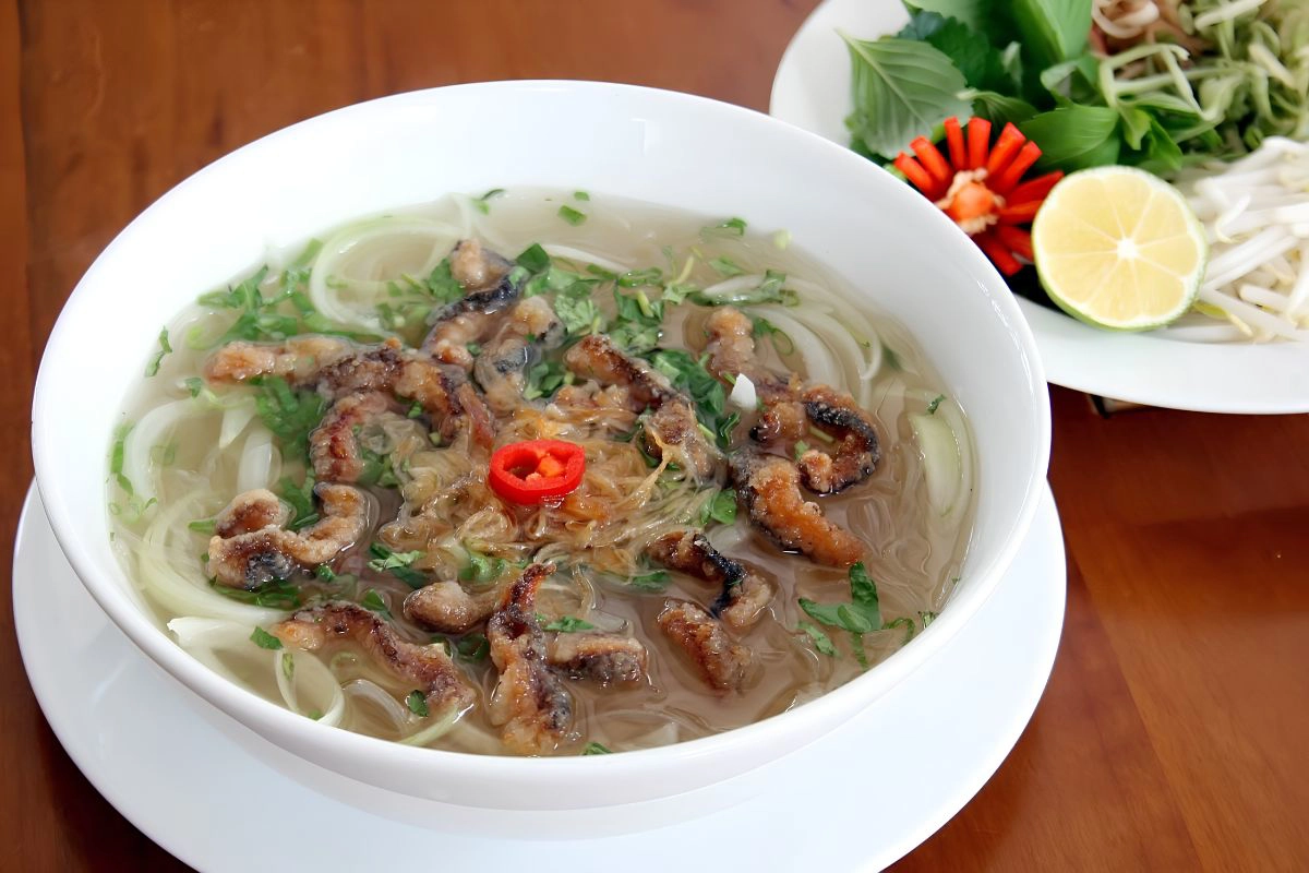 A warm bowl of authentic eel glass noodle soup with fresh herbs