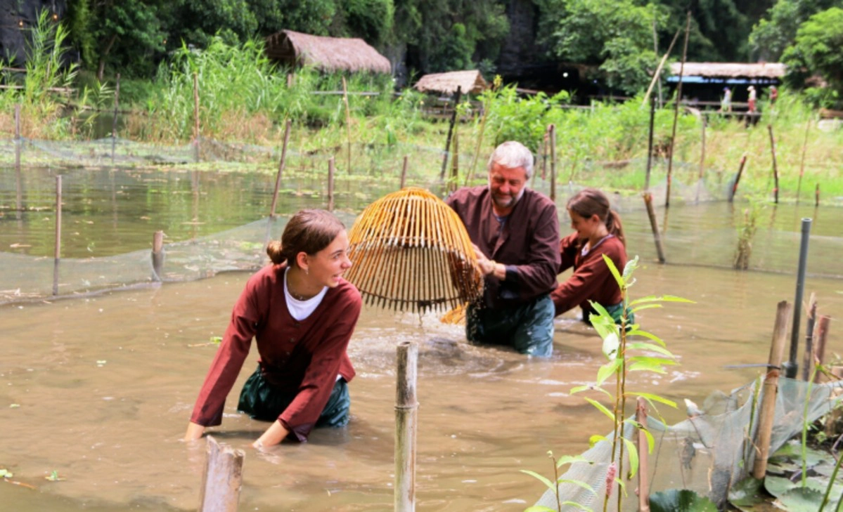 Family enjoys traditional fish trapping in the fields near Buffalo Cave, Ninh Binh