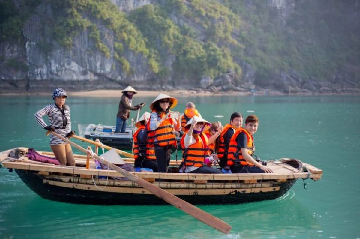 Tourists in life jackets riding a traditional bamboo boat 