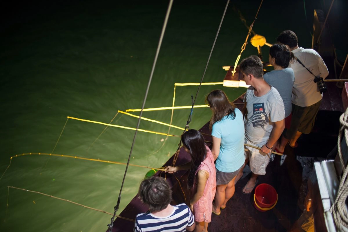 Guests gathering under bright lights to catch fresh seafood