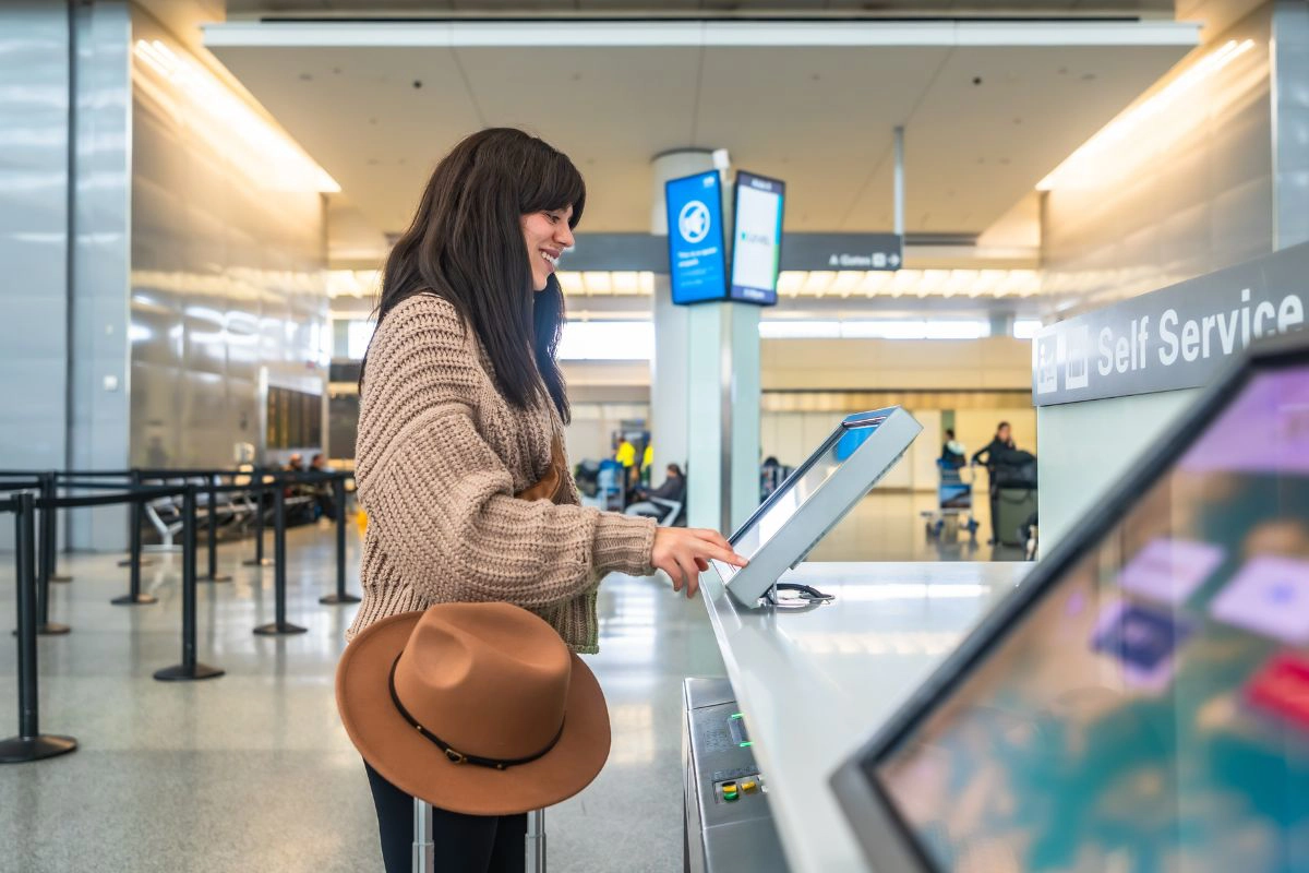 Travelers checking luggage at a busy airport terminal counter