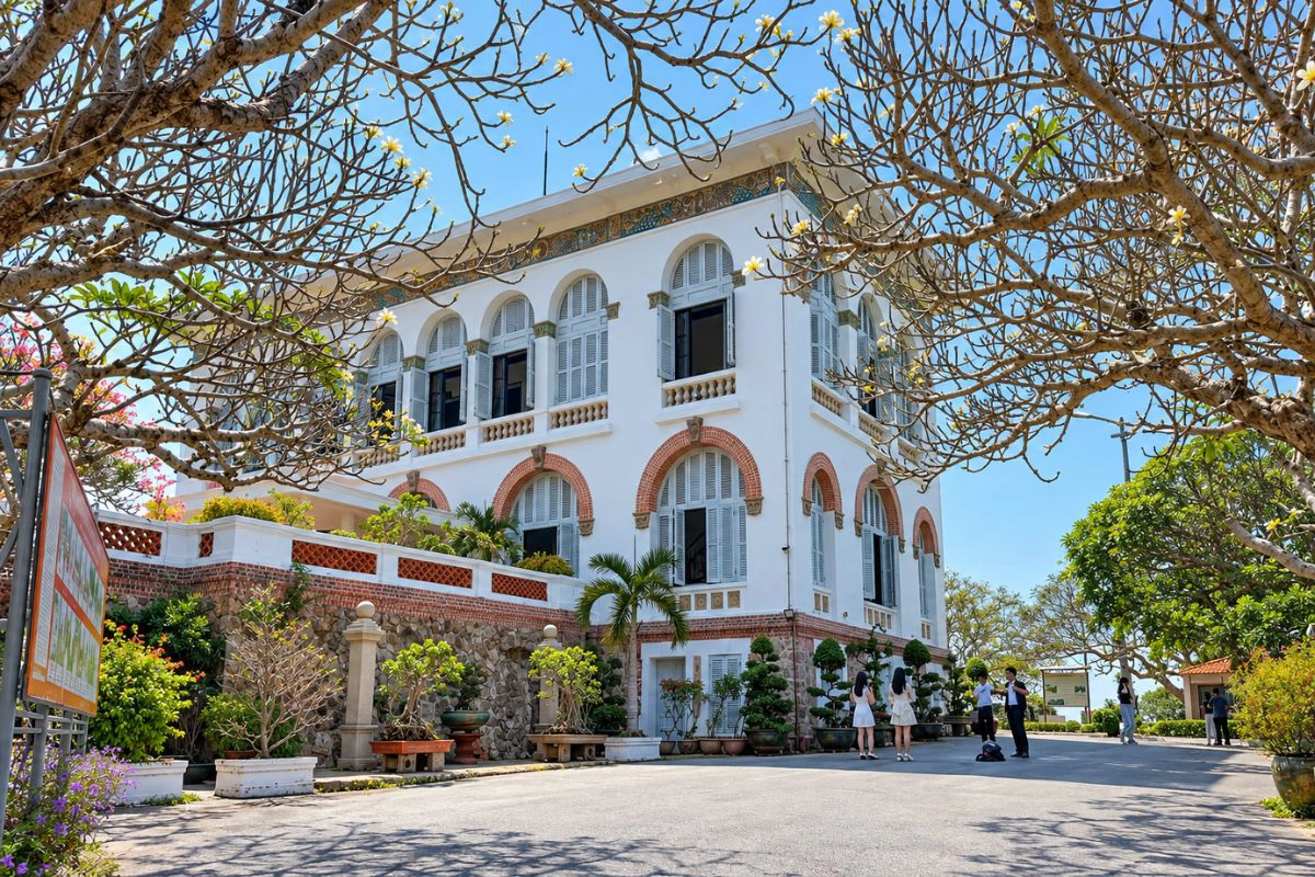 The white villa rises above a staircase lined with old frangipani trees